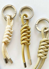GOLDEN collection THE STABLE BAG CHARM -TWISTSnygga nyckelringar, bag charms i para cord i guldiga nyanser och cromad logo präglad rund ring