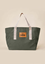 Lope Tote Bag Gröngrå stallväska./grooming bag Tyg: 900D polyester i grågrön färg. Axelband: Vävda band i crèmevitt med nedsänkt text LOPE SPORT. Sömmar: SPI (stitches per inch): 8–9. Foder: Dubbelt tyg (samma polyester även som insida). Tråd: Nylon, med hög slitstyrka. Logo-lapp: Cognacsfärgat PU-läder med svart nedsänkt präglad logotyp. Stängningsrem: Cognacsfärgat PU-läder med tryckknapp i antik mässing präglad med logotyp. Uppifrån foto