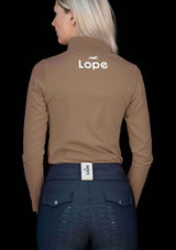 En långärmad funktionstopp i beige med halvpolokrage och dragkedja. Toppen har raglanärmar, en slimmad passform och fyrvägsstretch för rörelsefrihet. Den är snabbtorkande och fuktabsorberande, med tryck i vitt på vänster ärm och rygg. Perfekt för ridning i svalare väder