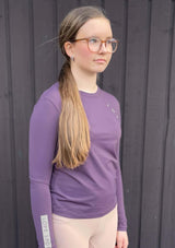 lila långärmad ridtopp för juniorer. lope tryck på bröstet och ärmen. lätt och luftig