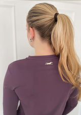 En lila långärmad tröja i ett mjukt, silkesliknande material. Tröjan har rund halsringning och ett upphöjt häst 3D-tryck i silikon i nacken samt "LOPE SPORT" tryckt längs ena ärmen.