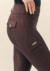 ridbyxor dam . ridklädd kvinna i flow bruna ridbyxor för dam med knappar i guld. mobilficka med hst i guld brodyr