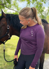 En lila långärmad tröja i ett mjukt, silkesliknande material. Tröjan har rund halsringning och ett upphöjt 3D-tryck i silikon med texten "LOPE" snett över bröstet samt "LOPE SPORT" tryckt längs ena ärmen.