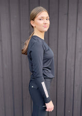 Svart långärmad ridtopp för juniorer. Lope tryck på ärm och bröst. Luftigt funktionsmaterial