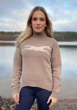 Lope wool polo knit tröja i 100% ull - Toffeemelange worn by a model near a lake, showcasing its stylish design.