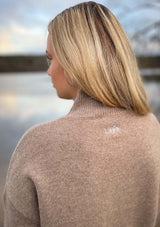 Lope wool polo knit tröja i 100% ull - Toffeemelange. En långärmad, finstickad tröja i ull. Tröjan har lös passform, ribbstickad halvpolo och nedhasad axel. Ribbstickad kant vid ärmslut och nedtill samt sprund i sidorna.Broderad lope logotyp i nacken.