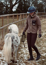 noomi skobe rosén i lope stable fleece med windstopper funktion. liten shettis häst