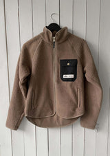 Fleecejacka junior windstopper, LIGHT GOLDEn beige fleecejacka med windstopper-funktion, hel dragkedja framtill och en svart bröstficka med präglad guld knapp och etikett. Jackan har hög krage, två sidofickor med dragkedja och en längre rundad nederkant baktill