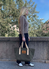 Lope Tote Bag Gröngrå stallväska/grooming bag. Tyg: 900D polyester i grågrön färg. Axelband: Vävda band i crèmevitt med nedsänkt text LOPE SPORT. Sömmar: SPI (stitches per inch): 8–9. Foder: Dubbelt tyg (samma polyester även som insida). Tråd: Nylon, med hög slitstyrka. Logo-lapp: Cognacsfärgat PU-läder med svart nedsänkt präglad logotyp. Stängningsrem: Cognacsfärgat PU-läder med tryckknapp i antik mässing präglad med logotyp