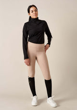 ridklädd tjej i svart sport topp, soft beige funktions ridbyxor, svarta kompressions strumpor för ryttare från lope.se