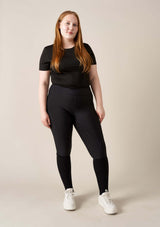 ridklädd kvinna med svarta funktions ridbyxor med kompression i storlek large