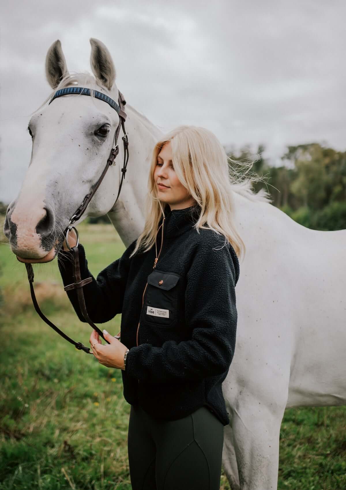 stable fleece svart på modell med häst
