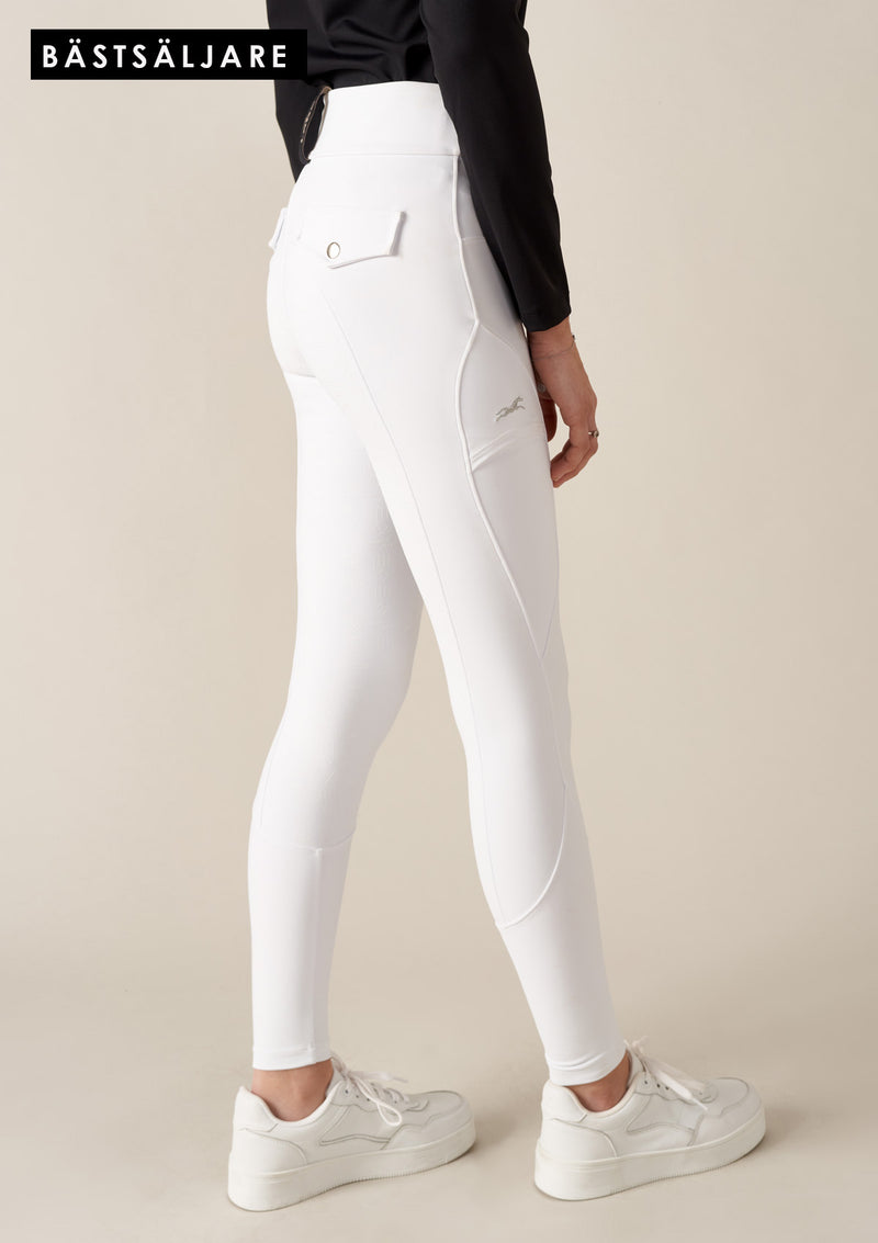 best seller -Vita tävlingsbyxor. Bekväma ridbyxor med hög midja och skulpterande passform. Tillverkade i fyrvägsstretch för optimal rörelsefrihet, med en mobilficka med lock och broderad häst. Helskodda med grip för rätt friktion i sadeln. True to size och med en Stay-in-place garanti som säkerställer att byxorna sitter uppe oavsett kroppsform