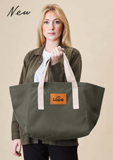 Lope Tote Bag Gröngrå stallväska. Tyg: 900D polyester i grågrön färg. Axelband: Vävda band i crèmevitt med nedsänkt text LOPE SPORT. Sömmar: SPI (stitches per inch): 8–9. Foder: Dubbelt tyg (samma polyester även som insida). Tråd: Nylon, med hög slitstyrka. Logo-lapp: Cognacsfärgat PU-läder med svart nedsänkt präglad logotyp. Stängningsrem: Cognacsfärgat PU-läder med tryckknapp i antik mässing präglad med logotyp