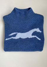 Blå långärmad, oversize finstickad tröja i 100 % ull med hästmotiv. Den har en mjukt ribbstickad halvpolo, nedhasade axlar och en avslappnad silhuett. Ribbstickade muddar vid ärmslut och nederkant samt små sprund i sidorna för en följsam passform.