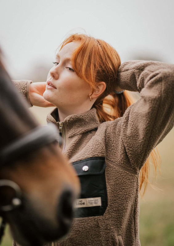 stable fleece i varm beige med svart ficka och detaljer i light gold. mjuk teddy med vindtött fodet