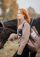 kvinlig femenin stable fleece i varm beige med svart ficka och detaljer i light gold. mjuk teddy med vindtött fodet