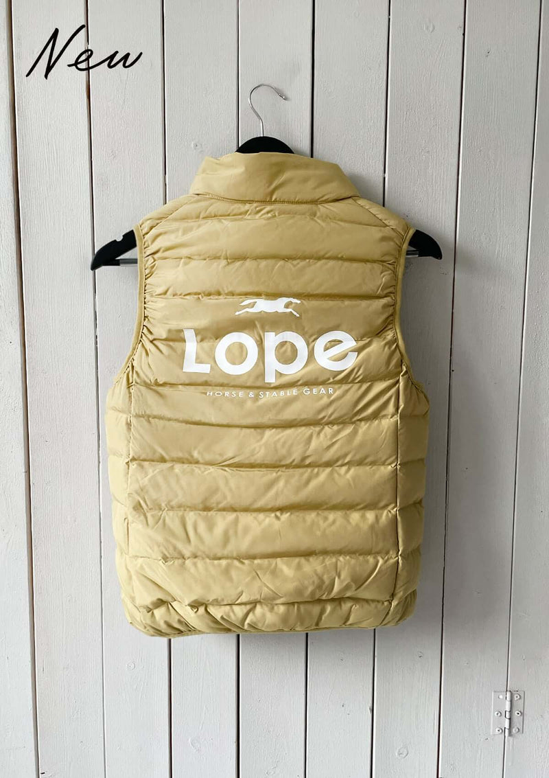 En gul dunväst för ridning med horisontella quiltade sömmar. Västen har hög krage och stort vitt tryck på ryggen med texten "Lope Horse & Stable Gear" samt en springande hästsilhuett ovanför loggan