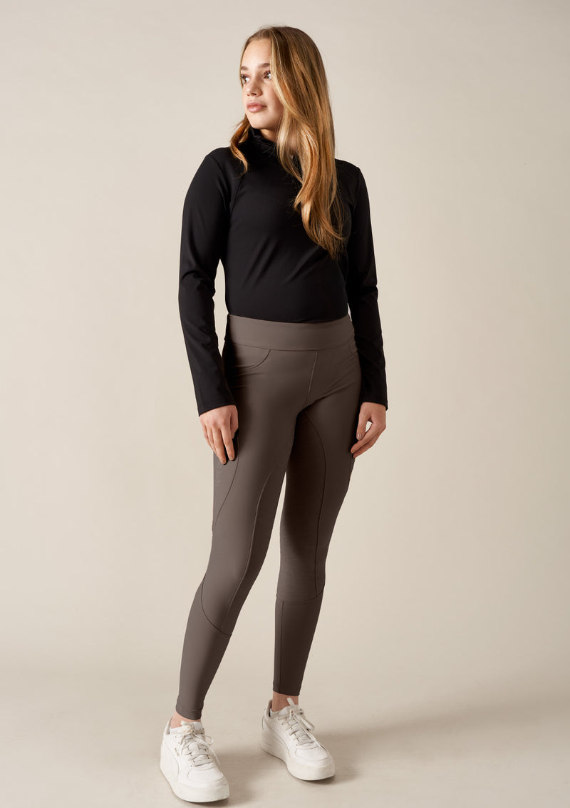 The Flow  i  fyrvägsstretch,  färgen velvet clay. Den höga midjan ger stöd och en smickrande siluett,  mobilficka med lock och broderad guld häst. bakfickor med knappar i guld med vår logo.