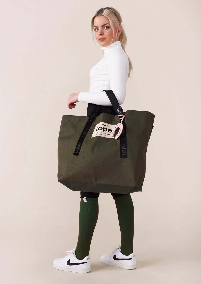 Grön ridväska i tote bag modell. Stilren design.När det kommer till packning, är vår Champion Bag mästaren! Med sin sportiga look och rymliga design gör den det enkelt att packa allt du behöver och mer därtill. Bär den på axeln eller i handen.